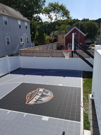 View from side and above of most of Boston, MA silver and black home basketball court featuring unique Hoop Head logo.