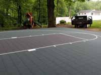 Home basketball court in subdued slate green and burgundy on asphalt in Connecticut.