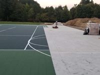 The concrete base getting surfaced with quality court tiles in the final phases of court construction in Easton, MA.