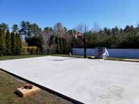 Concrete court base before installing tiles for Titanium and navy blue residential basketball court in Hanson, MA. Form for pouring cement for court base shown here.