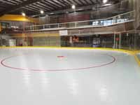 We traveled to Kapolei, Hawaii and inside to resurface two inline skate hockey rinks with Versacourt Speed Indoor tile. This is a picture of one end of the finished first court, showing all of one of the zone circles.