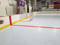 We traveled to Kapolei, Hawaii and inside to resurface two inline skate hockey rinks with Versacourt Speed Indoor tile. This is a finished view showing part of the center line and along one side.