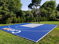 Square on view of most of finished blue basketball court with fencing in Foxboro, MA.