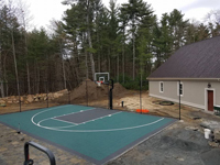Green and charcoal home basketball court installed in the midst of ongoing construction in Marion, MA.