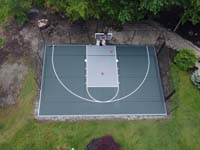 Dark green and silver residential basketball court from almost directly overhead in North Reading, MA. Includes increasingly ubiquitous lines for secondary use playing pickleball.