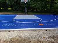 The words CENTER COURT on a small backyard basketball court, with the O in court replaced by an orange basketball.