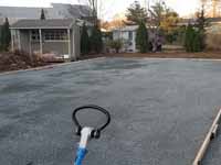 Photo from installation of a sand and emerald green residential backyard basketball court in Swampscott, MA. A better underlay makes a better, longer lasting base. Doing it right with hard packed crushed stone.