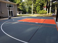 Charcoal and orange residential basketball court with pickleball lines, installed over a filled in pool in Walpole, MA.