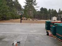 Partway through construction of multicourt with basketball, pickleball, shuffleboard and hoscotch as part of complete revamp of Yogi Jellystone Cranberry Campground in Cartver, MA. Concrete base and goals installed, pallets of surface tiles ready to finish it.