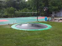 We installed the in-ground trampoline in the foreground, along with the green and red background court for various sports in Pembroke, MA.