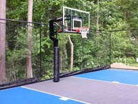 Focus on hoop and rebound fence of blue and grey West Bridgewater basketball court.