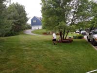 View of lawn before constructing red and grey home basketball court in Groton, MA.