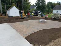 Partially completed construction of a basketball court featuring Celtics logo, with fire pit, patio, and light for night play, in Londonderry, NH.