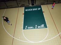 Overhead view of inspirational phrases on basketball court key: never give up, and I can, I will.