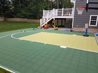 View after landscaping was completed around it of a Needham, MA basketball court in colors of olive and pistachio. The pistachio option has been discontinued.