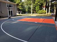 Graphite and orange basketball court in Walpole, MA, installed over a filled in pool.