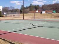 Resurfaced municipal basketball courts in Walpole, NH to create a combo of pickleball and basketball on comfortable, durable royal blue and graphite versacourt tile. This shows part of the old court that was replaced.