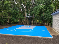 Backyard basketball on existing bas, featuring pirate logo and tiles of light blue and silver, in Bedford, MA.