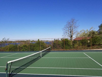 Side view across resurfaced tennis court, adjacent to net, in Bristol, RI.
