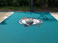 Closer view of custom logo on green key on home basketball court in Brockton, MA.