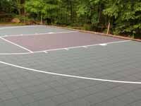 Home basketball court in subdued slate green and burgundy on asphalt in Connecticut.