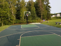Similar view down most of length of basketball court after tiled surface in greens was installed in Dartmouth, MA.