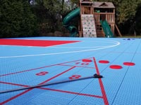 Closer look at basketball court tile surface and shuffleboard add-on in Dartmouth, MA.