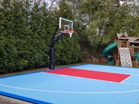 Home basketball court in Dartmouth, MA, bordered in royal blue, primarily in light blue, with red key, featuring added shuffleboard and accessories, and a quality goal system.