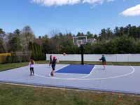 People enjoying new Titanium and navy blue residential basketball court in Hanson, MA.