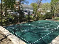 All green backyard basketball and pickleball nestled into landscape in Hingham, MA.