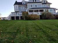 Hillside front lawn looking toward house in Hingham, MA before the yard was transformed and we installed a large hockey/basketball multicourt.