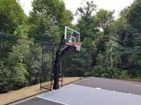 Charcoal and titanium Cape Cod backyard basketball court in Barnstable village of Marstons Mills, MA. Close-up view of hoop system.