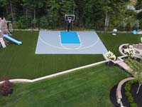 Silver and blue residential basketball court in low drone view in Middleton, MA.
