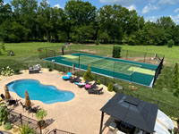 Example of a large home multicourt in shades of green, adjacent to a pool, feturing basketball pluse pickleball and other net sports.
