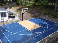 Overhead angle view toward hoop of blue and peach or salmon basketball and pickleball court in Randolph, MA.