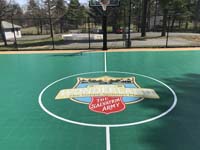 Closeup of the Camp Wonderland logo at the center of a basketball court in Sharon, MA.