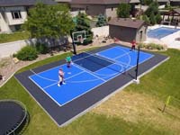 Example of home basketball court plus basketball, featuring SnapSports surface in black and two shades of blue.