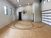 Example picture of indoor home basketball court option available, featuring SnapSports surface tile product.