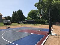 Angled view across court from right rear, featuring basketball and pickleball, lighting for night play, and three tile surface colors. South Windor is ready for fun.