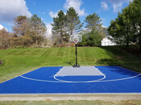 A straight on view of blue and silver Southborough, MA basketball court, looking toward the goal.
