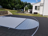 Residential backyard basketball court in charcoal and titanium colors in Wellesley, MA.