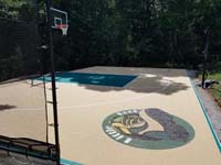 Side view of sand and green colored basketball court at home in Islington section of Westwood, with Little Boot logo visible in foreground.