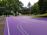 View of extensive portion of new purple sport surface on existing asphalt at Williams College, in Williamstown, MA.
