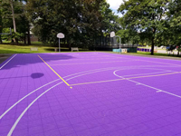 Existing asphalt court at Williams College in Williamstown, MA, resurfaced with purple Versacourt tile, painted with white and yellow lines for volleyball and basketball.