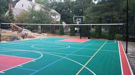 Backyard basketball court plus tennis and volleyball in Pembroke, MA, featuring green and red Versacourt tiles.