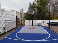 Blue and grey small backyard basketball court with custom red H logo in Braintree, MA.