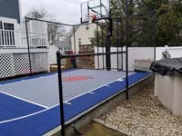 Small blue and grey basketball court by pool in Braintree, MA.