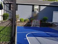 Blue and grey basketball court in Braintree, MA, after finishing landscape and hardscape touches around it were completed.