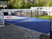 Outstanding blue court in a small backyard space, featuring a titanium colored key and a custom stylized red H logo, installed for a happy customer in Braintree, MA.