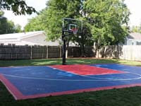 Small red and blue backyard basketball court in Canton, MA.